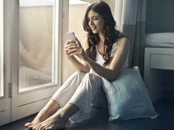 A young woman sat on the edge of the bed.